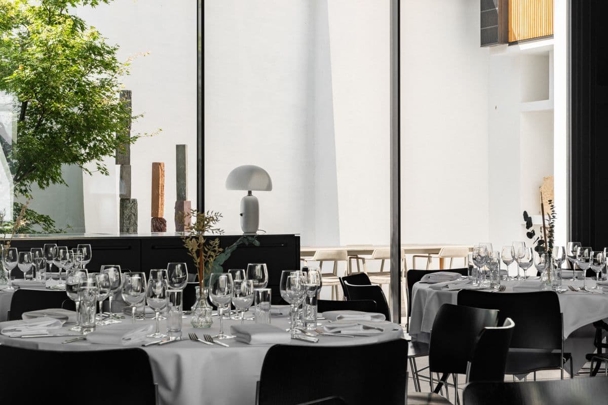 Elegant tables set up in the Garage at Mogens Dahl Concert Hall, ready for a corporate party with a focus on atmosphere and quality – ideal for themes, events, or dinners.