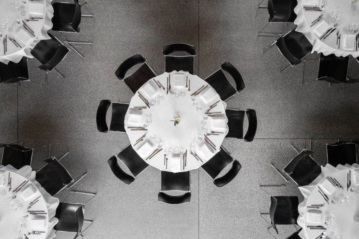 Overhead photo of tables and chairs set up and decorated for an event in the Garage at Mogens Dahl Concert Hall. The image shows the elegant table settings and meticulous event arrangement from a bird’s-eye perspective.