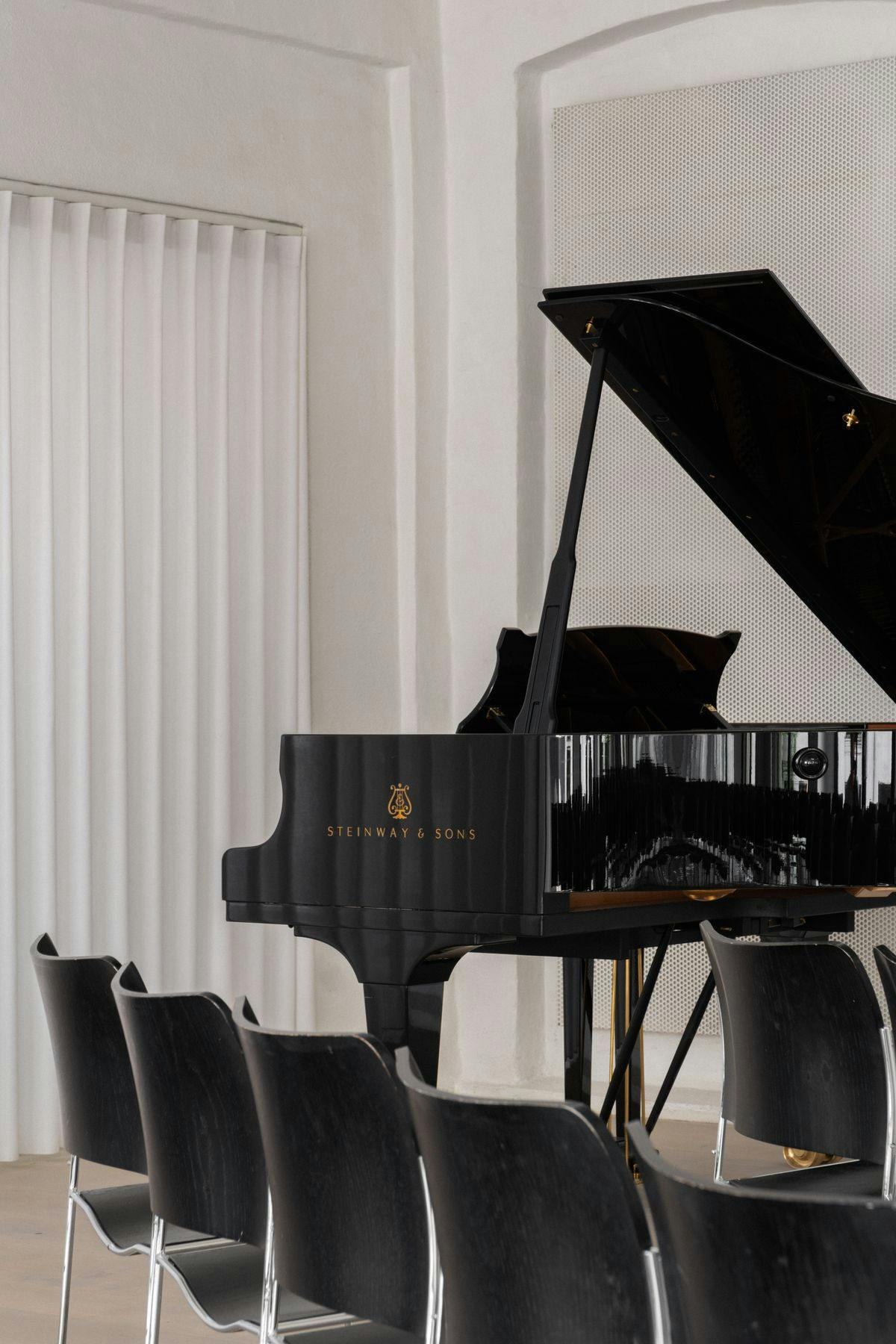 Photo of a piano in the Concert Hall at Mogens Dahl Concert Hall. The piano is part of the elegant decor used for musical performances and intimate concerts.