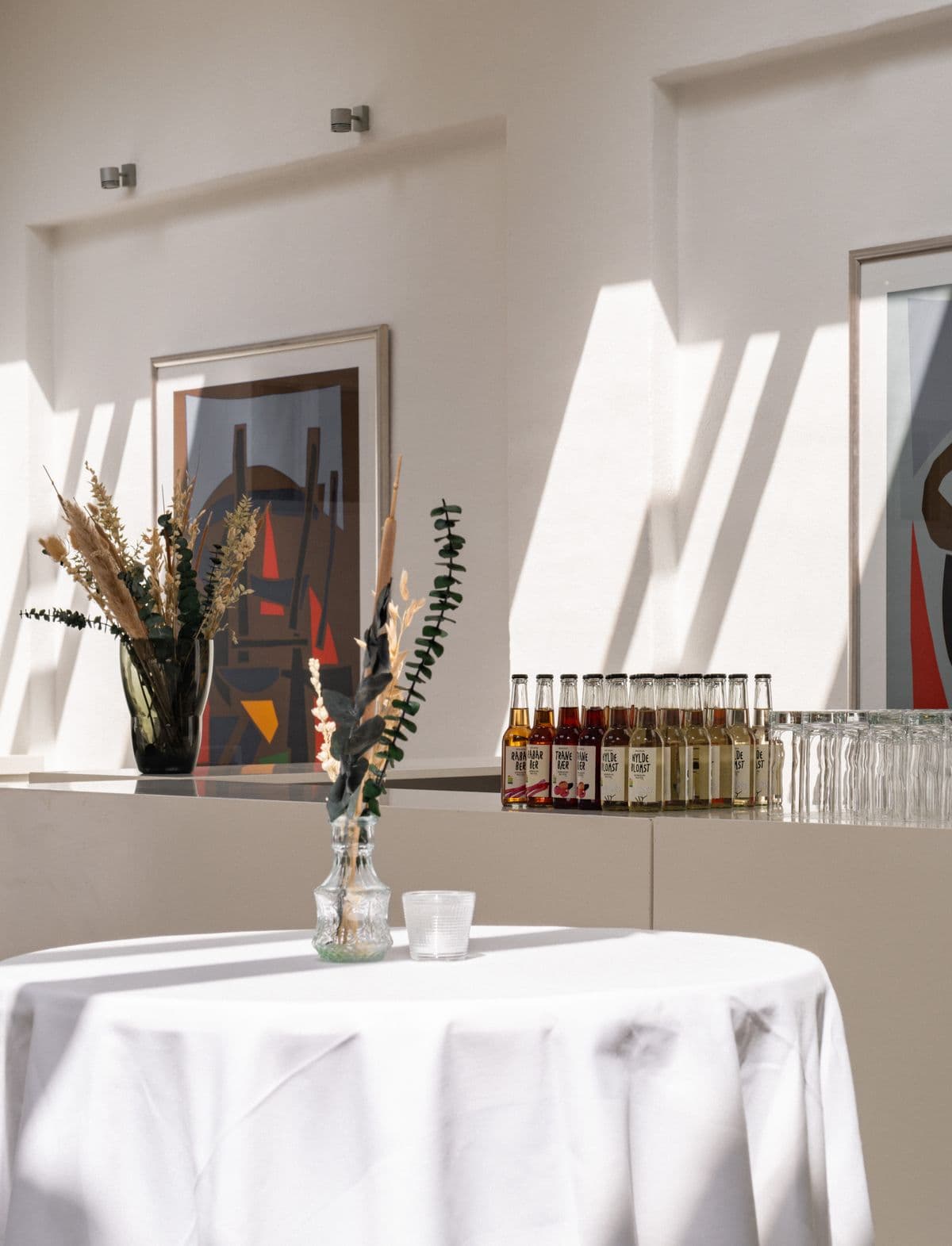 Image of the setup ready for an event in the Little Hall at Mogens Dahl Concert Hall. The picture shows tables arranged with various drinks, prepared for guests and creating a festive atmosphere.