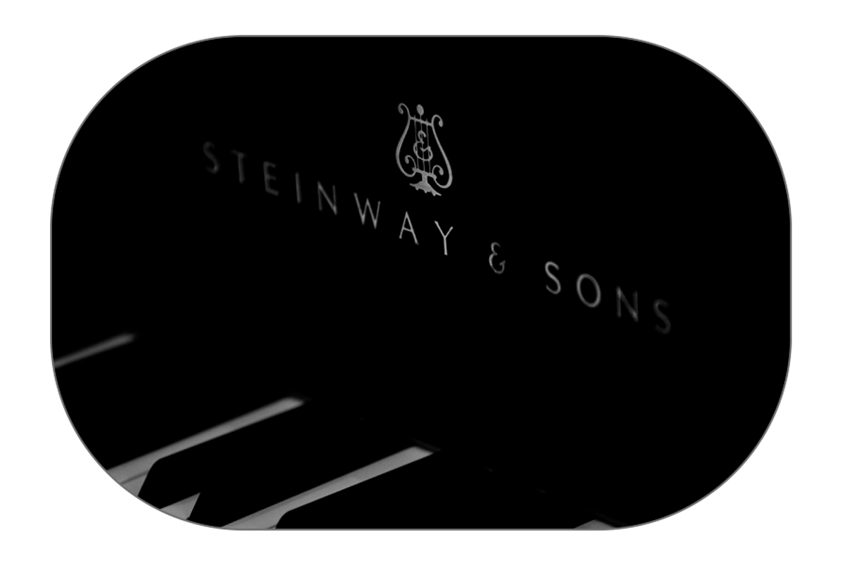 Black-and-white image of a detailed piano logo representing the elegance of music, as part of a page about gift cards for concerts at Mogens Dahl Concert Hall. The gift card offers the option to choose from various amounts for any concert of your choice.